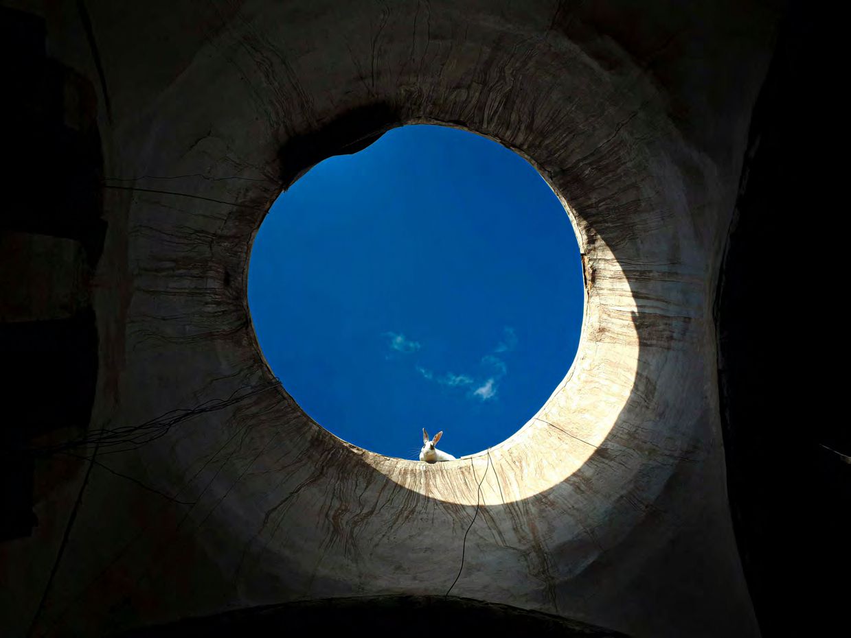 Bright sky through circular opening in structure.