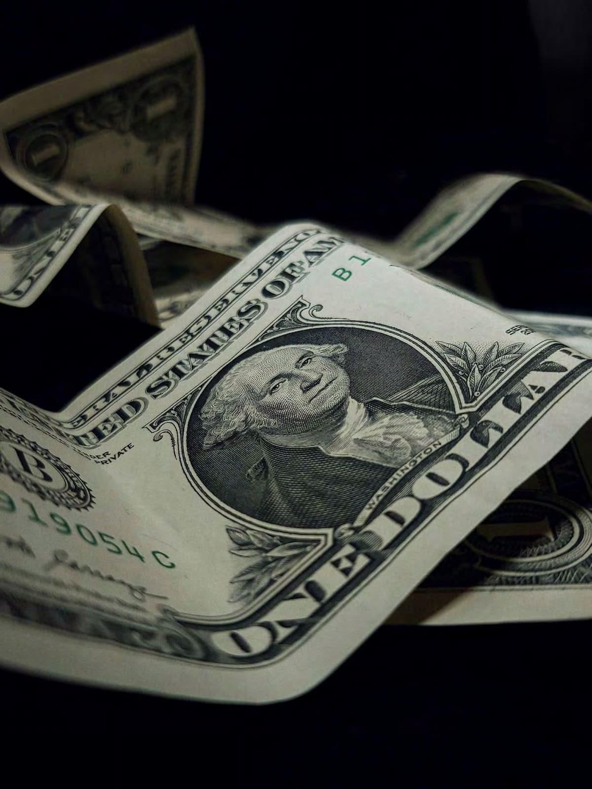 Close-up of one dollar bills in darkness.